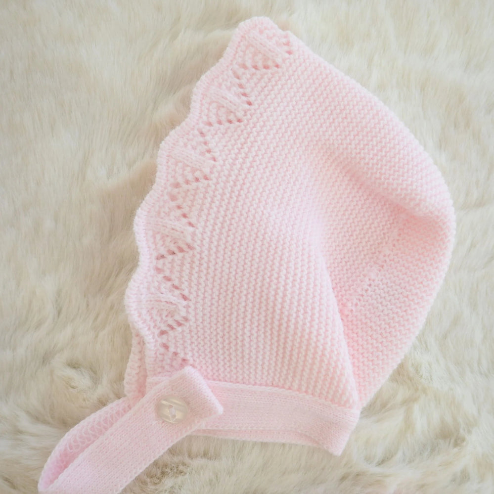 Pink 3-piece knitted baby outfit by Pex with bonnet, frill collar, and footed trousers – also available in white and beige