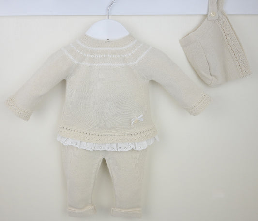 Flat lay of beige 3-piece knitted baby outfit with lace trim and bow detail
