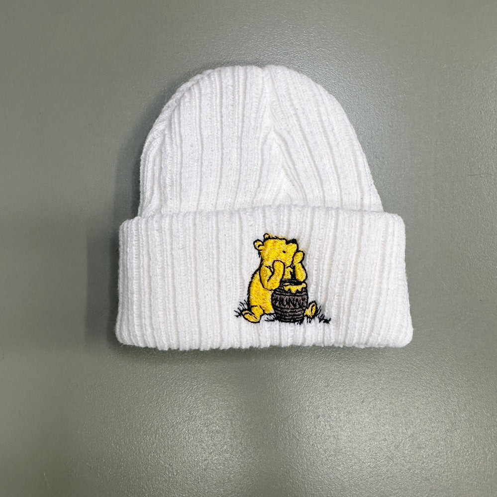 Newborn baby knit hat with embroidered bear design in soft neutral tones