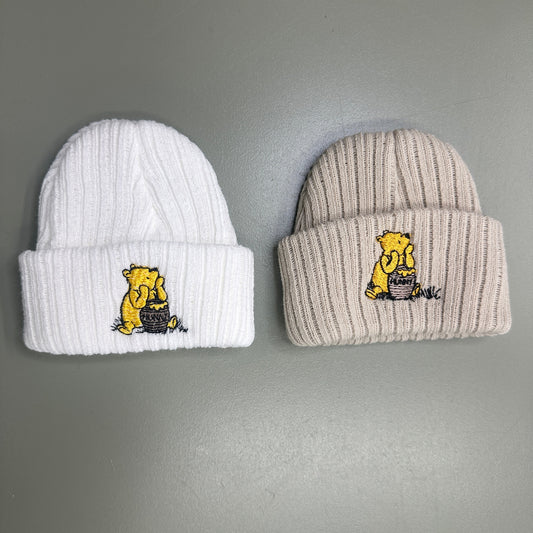 Newborn baby knit hat with embroidered bear design in soft neutral tones