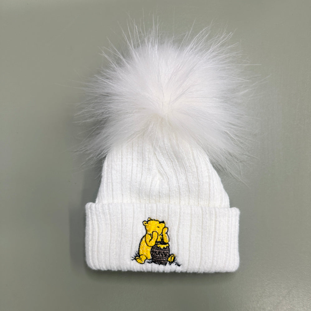 White and taupe Hunny Bear baby pom pom hats with embroidered bear motif