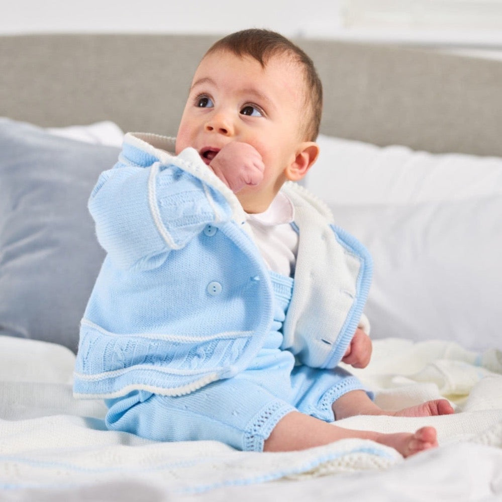 Blue knitted baby jacket with white hood lining and button front – warm and stylish outerwear for newborns to 12 months