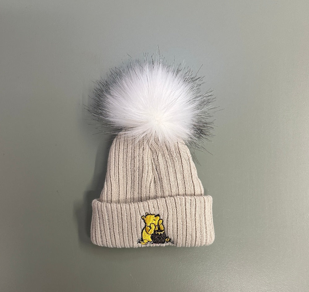 White and taupe Hunny Bear baby pom pom hats with embroidered bear motif
