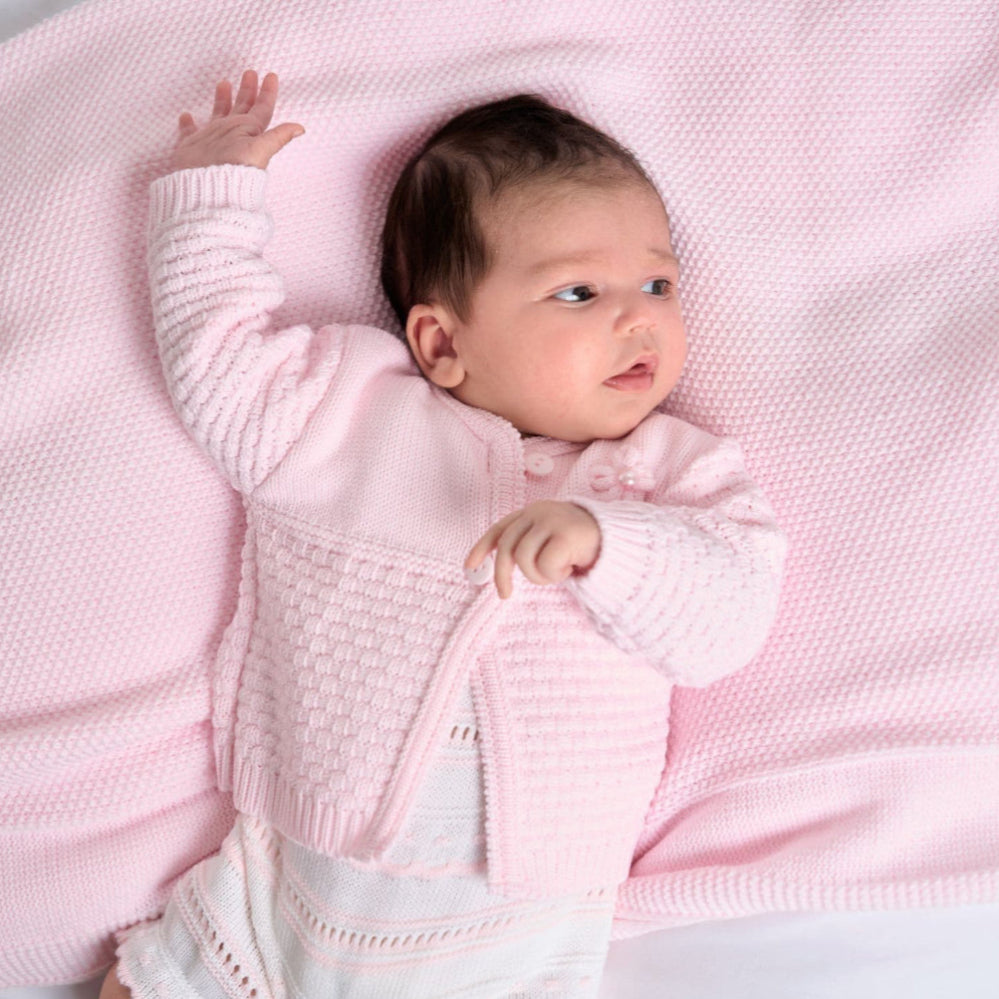Baby lying down wearing pink matinee cardigan – relaxed 