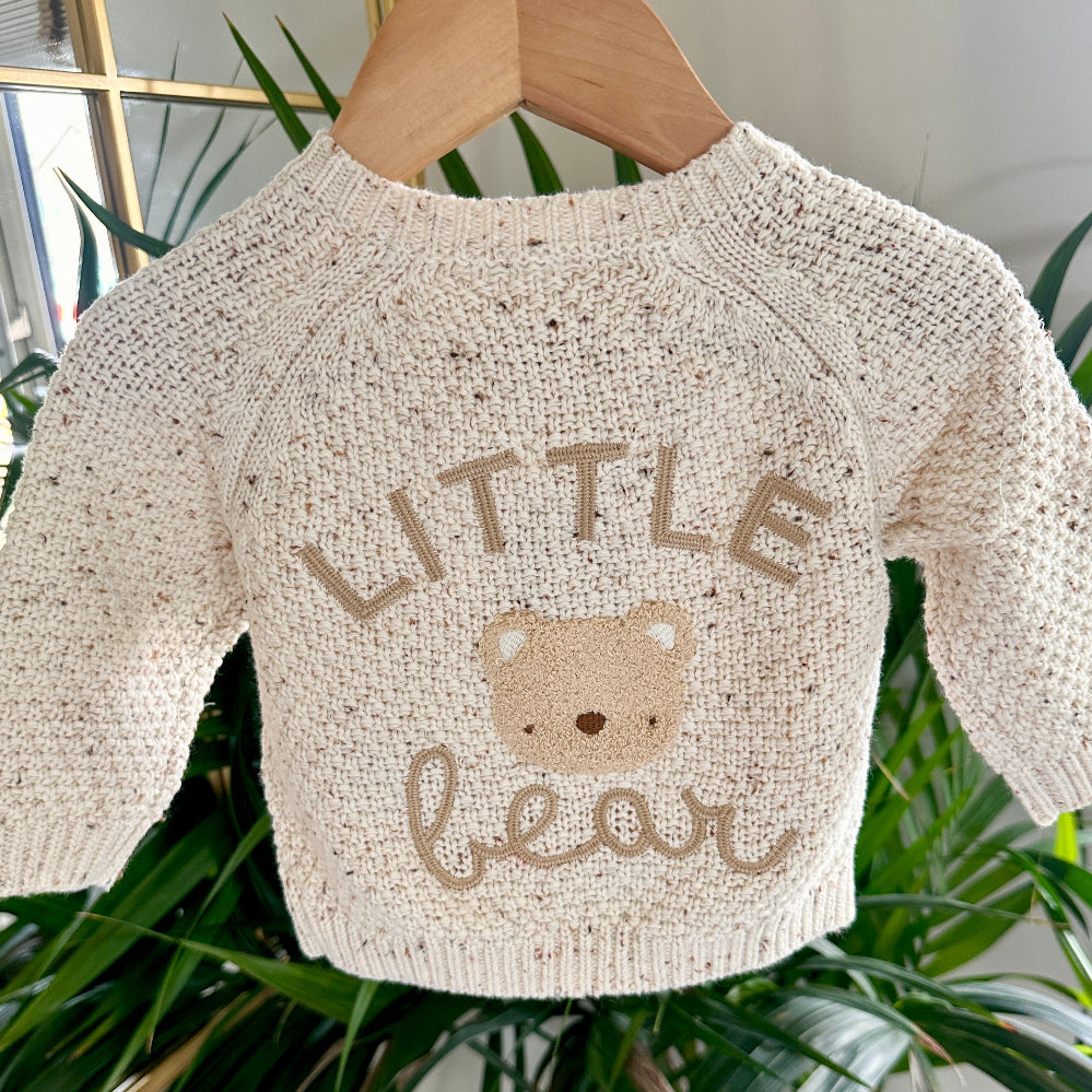 Close-up of oatmeal fleck cardigan with “Little Bear” and teddy bear face