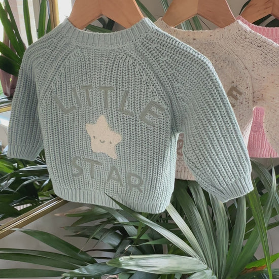 Three knitted baby cardigans in green, oatmeal fleck, and soft pink