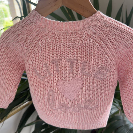 Three knitted baby cardigans in green, oatmeal fleck, and soft pink
